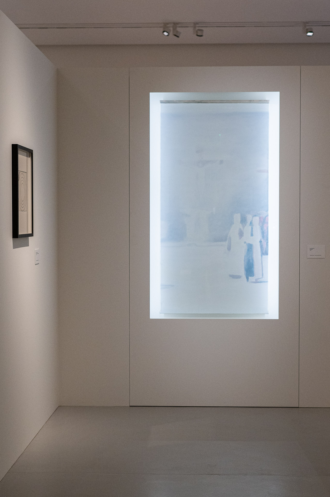 A single illuminated display case at the end of a darkened gallery at Abby.